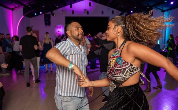 A photo of a man and a woman salsa dancing at Latino Arts Beats & Baile in Milwaukee, WI