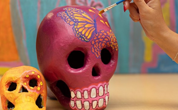 woman painting Two Calavera Skulls